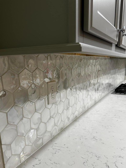 Pearlescent hexagon tile kitchen backsplash over white quartz countertop installed by Jeff Handyman