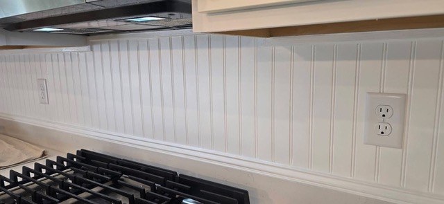 White beadboard kitchen backsplash behind a stainless gas range by Jeff Handyman