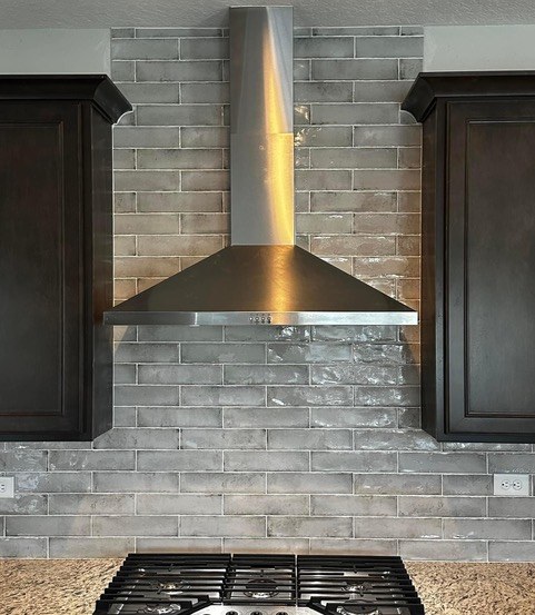 Gray subway tile kitchen backsplash with stainless range hood and gas cooktop installed by Jeff Handyman